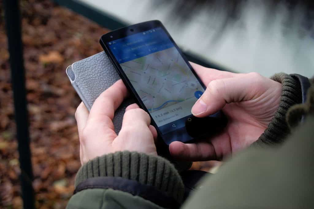 Person holding a phone with an app open, outside in autumn