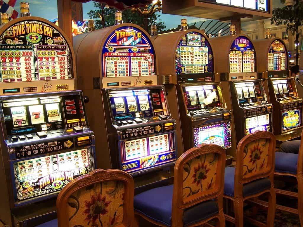 A row of slot machines in a brightly lit casino. 