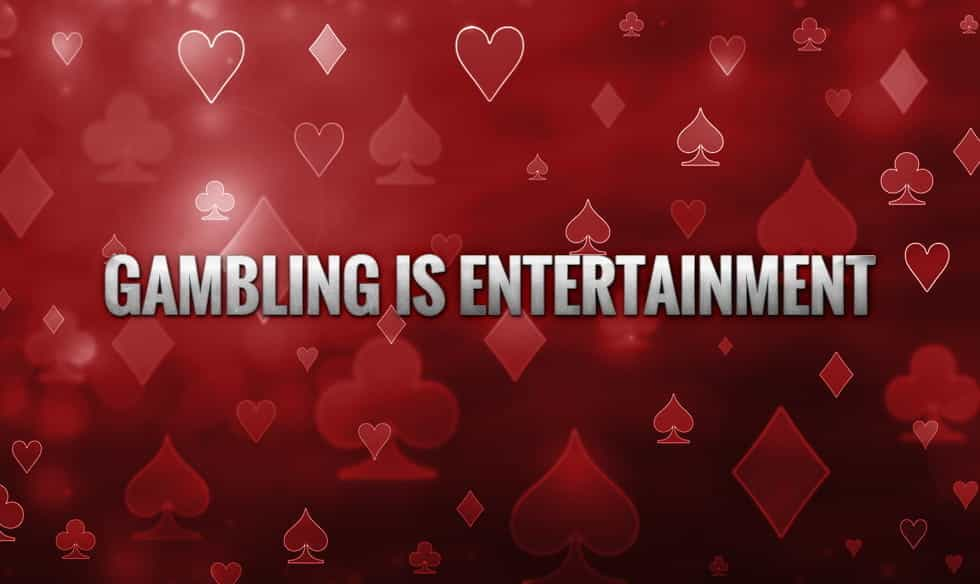 The words "gambling is entertainment", on a back drop of the four suits of cards.