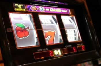 Three cherries appear on the first reel of a slot machine interface.