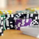 Several stacks of different colored gambling chips placed on a table.