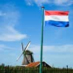 A flag against the blue sky on a pole.